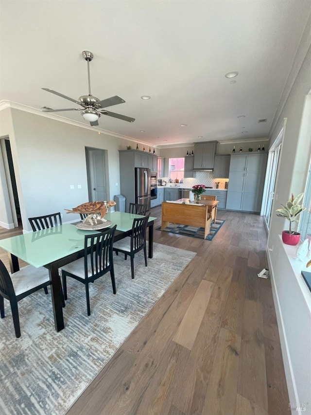dining room with ceiling fan, hardwood / wood-style floors, and ornamental molding