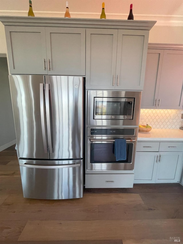 kitchen with decorative backsplash, dark hardwood / wood-style flooring, and stainless steel appliances