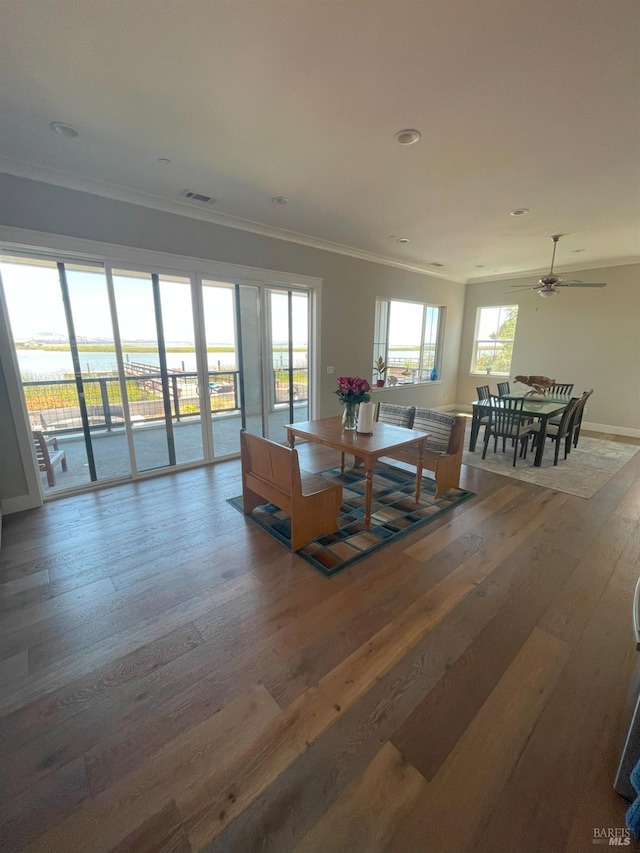 dining area with ceiling fan, wood-type flooring, and ornamental molding