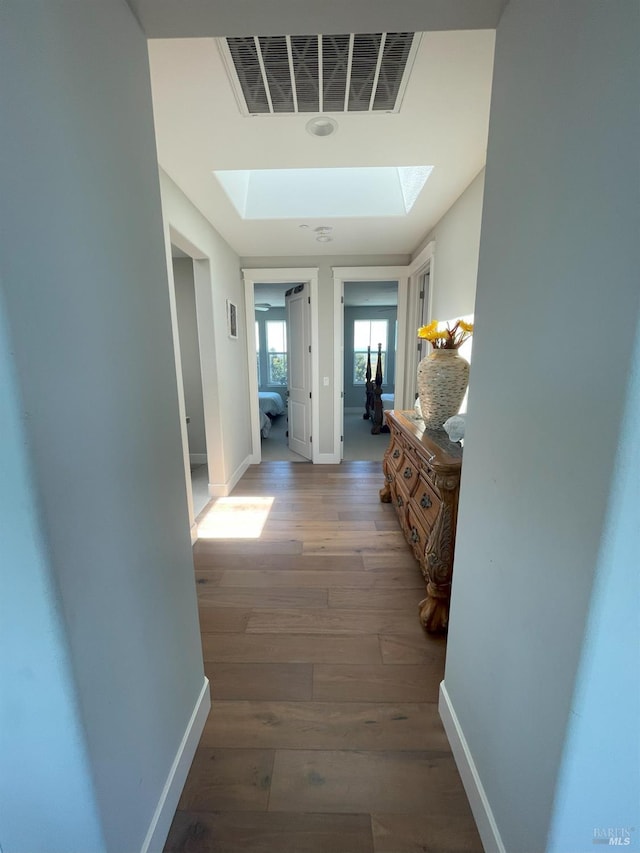 hallway featuring a skylight and dark hardwood / wood-style floors