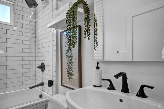 bathroom featuring tiled shower / bath and sink