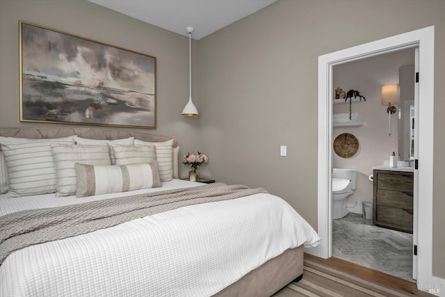 bedroom featuring ensuite bathroom and light wood-type flooring