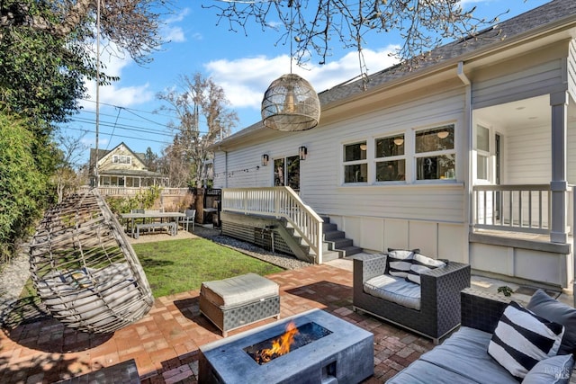 view of patio with an outdoor living space with a fire pit