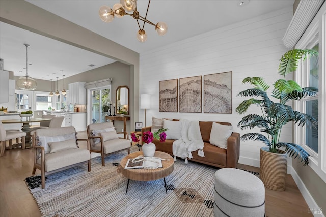 living room with light wood-type flooring and an inviting chandelier