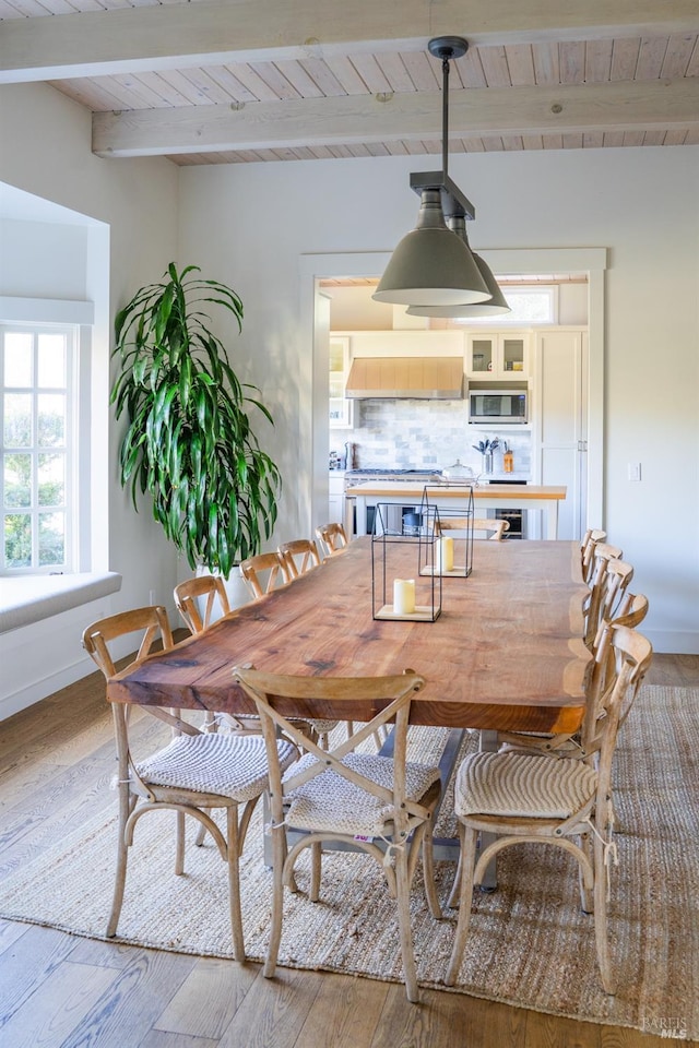 dining area with wooden ceiling, beam ceiling, and wood-type flooring