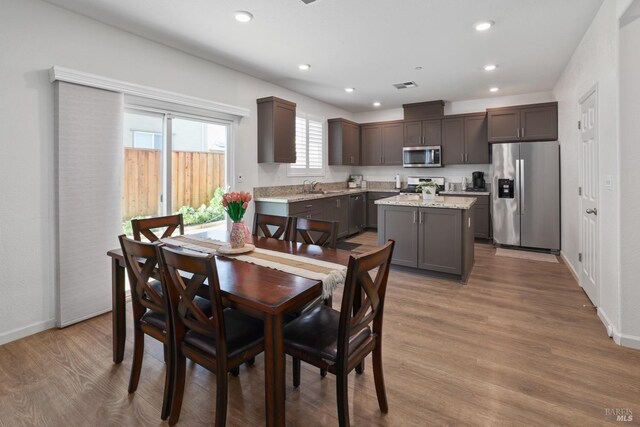 dining space with sink and light hardwood / wood-style flooring