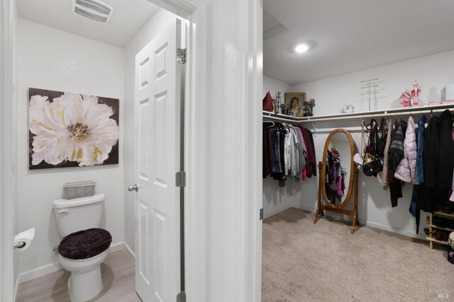 walk in closet featuring light carpet