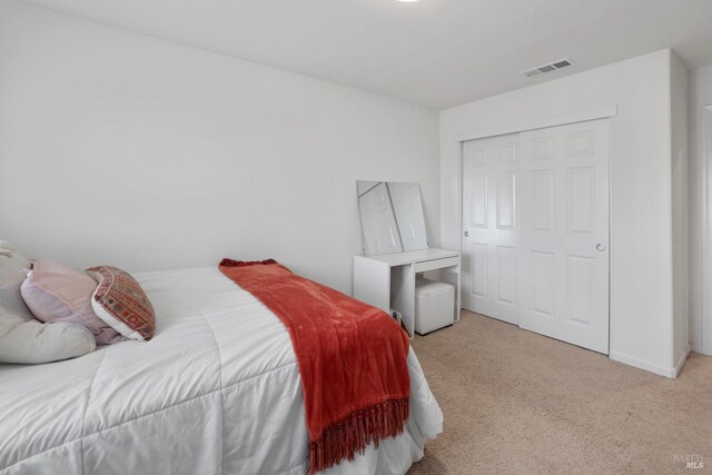 bedroom featuring light carpet and a closet