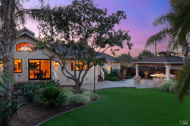 yard at dusk with a gazebo, an outdoor fire pit, and a patio area