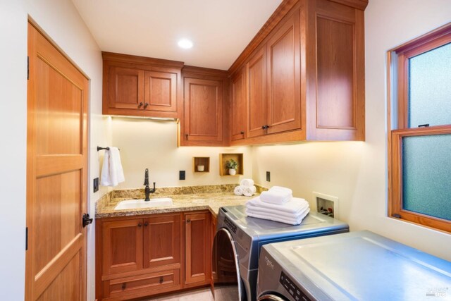 laundry area with cabinets, washer and clothes dryer, and sink