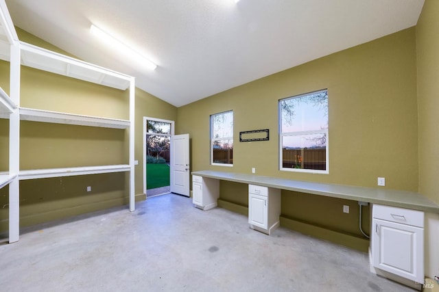 unfurnished office with lofted ceiling and built in desk