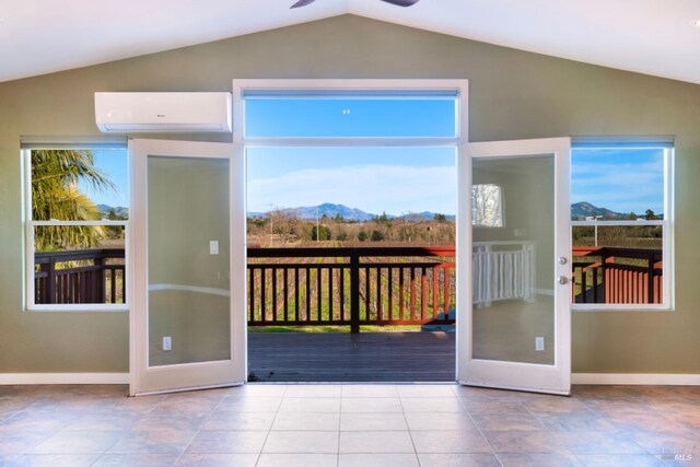 doorway to outside with french doors, lofted ceiling, an AC wall unit, a mountain view, and a healthy amount of sunlight