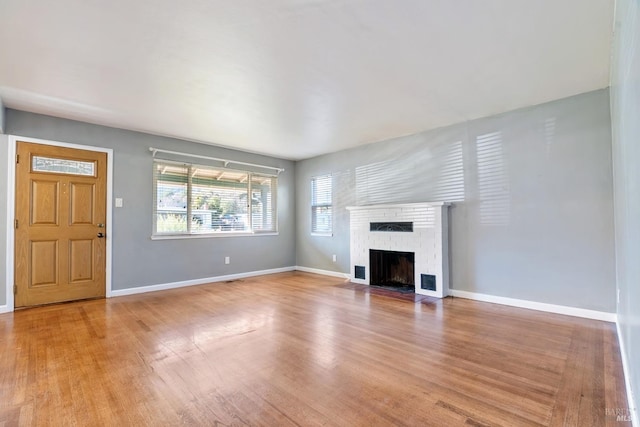 unfurnished living room featuring a fireplace and light hardwood / wood-style flooring