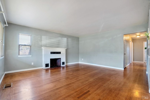 unfurnished living room featuring hardwood / wood-style floors and a fireplace