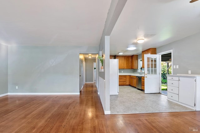 kitchen with sink, stainless steel dishwasher, and light hardwood / wood-style flooring