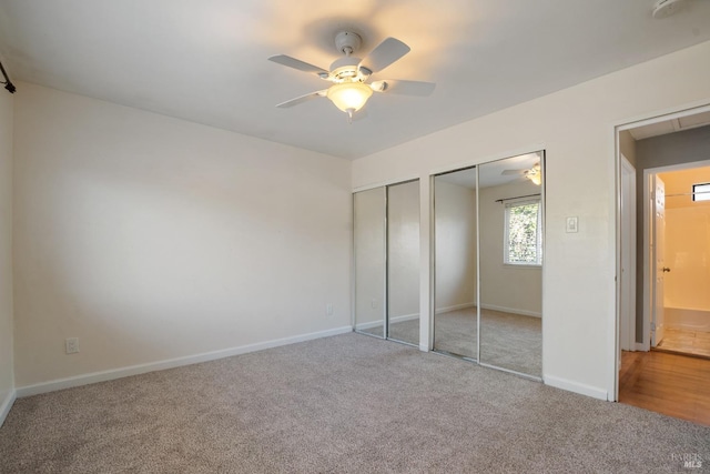 unfurnished bedroom featuring ceiling fan, carpet, and two closets