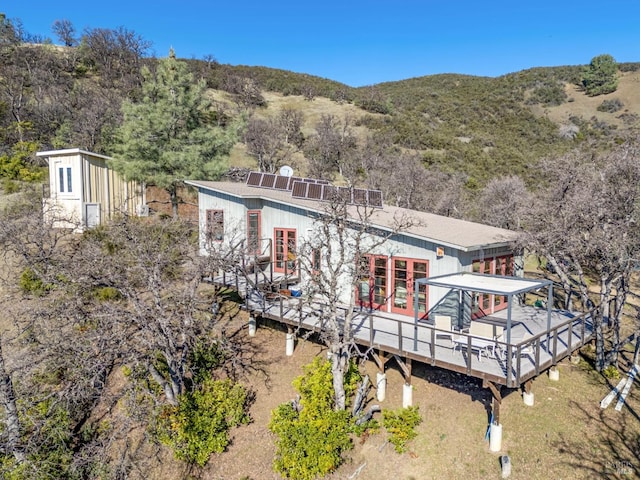 back of property with french doors and a wooden deck