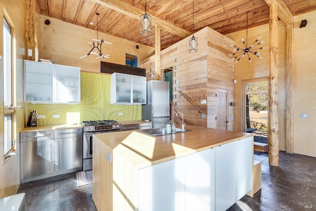 kitchen featuring hanging light fixtures, decorative backsplash, appliances with stainless steel finishes, and a center island