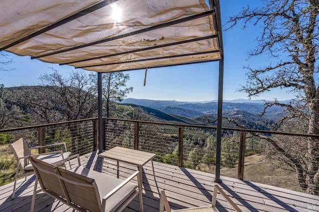 wooden terrace with a pergola and a mountain view