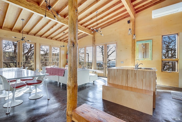 interior space featuring high vaulted ceiling, beam ceiling, and an island with sink