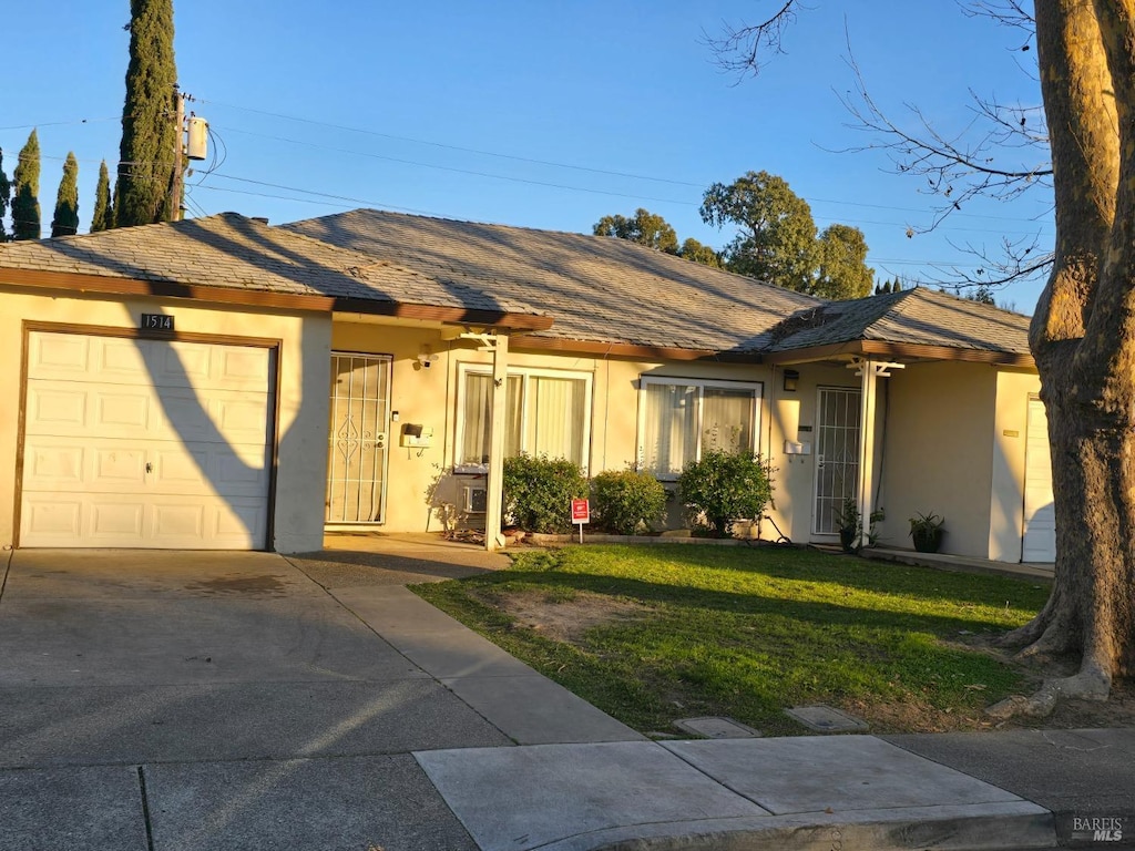 ranch-style home with a garage and a front yard