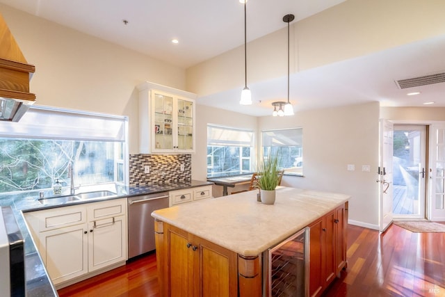 kitchen with sink, white cabinetry, hanging light fixtures, dishwasher, and beverage cooler