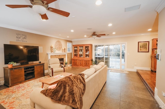 living room with crown molding, ceiling fan, and a fireplace