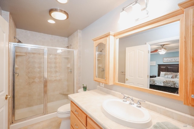 bathroom with an enclosed shower, vanity, tile patterned flooring, and toilet