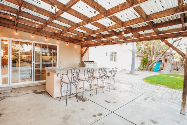 view of patio / terrace featuring a playground and a bar