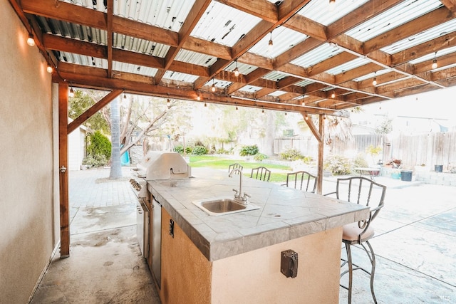 view of patio featuring an outdoor kitchen, a grill, and a wet bar