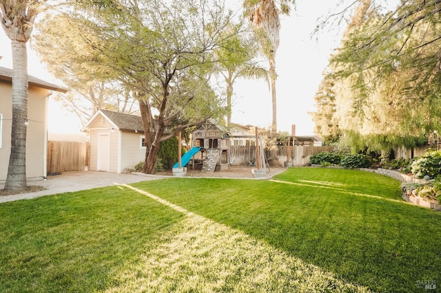 view of yard with a playground, a patio area, and a shed