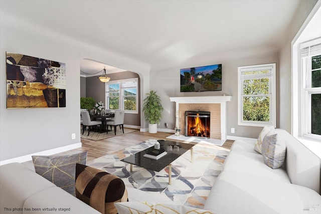 living room with wood-type flooring and a brick fireplace