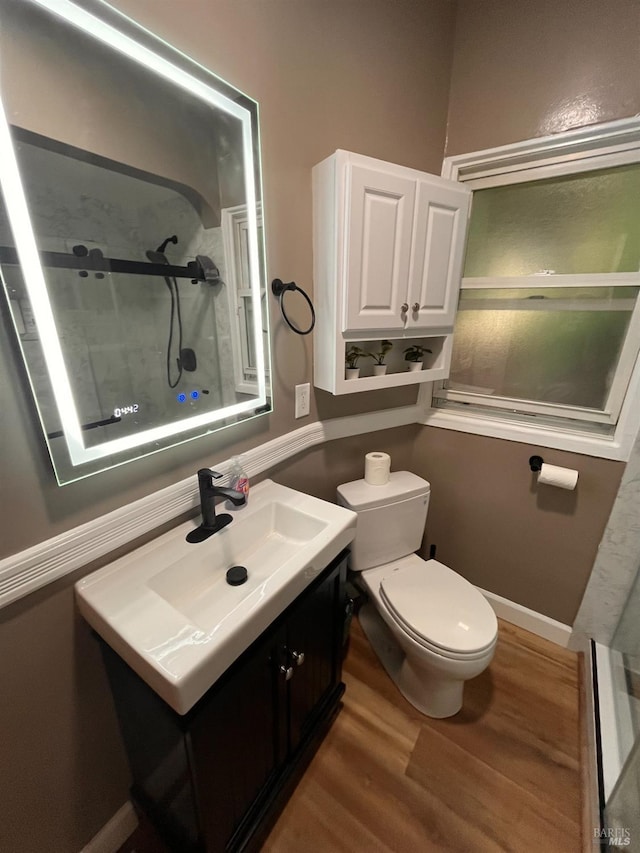 bathroom featuring walk in shower, vanity, toilet, and hardwood / wood-style floors