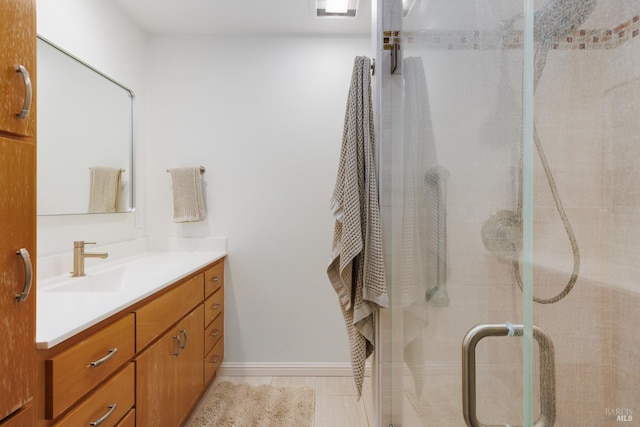 bathroom featuring a shower with shower door, tile patterned floors, and vanity