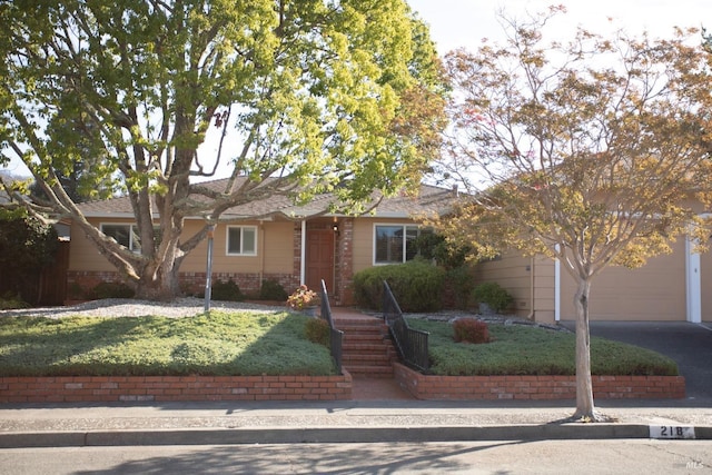 ranch-style house featuring a front yard and a garage