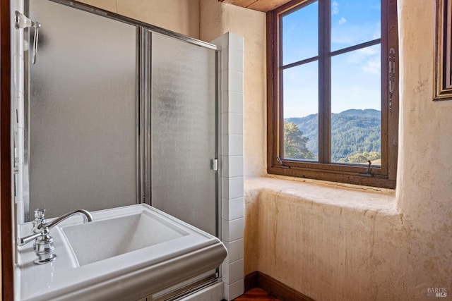 bathroom with sink, a mountain view, an enclosed shower, and plenty of natural light