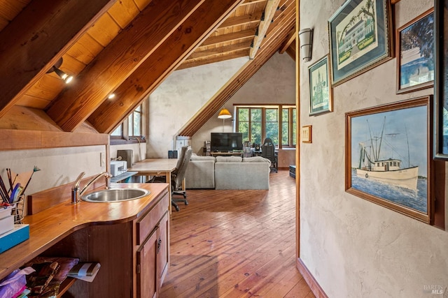 kitchen featuring light hardwood / wood-style floors, wooden ceiling, sink, and vaulted ceiling with beams