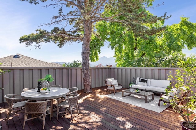 wooden deck with a mountain view and outdoor lounge area