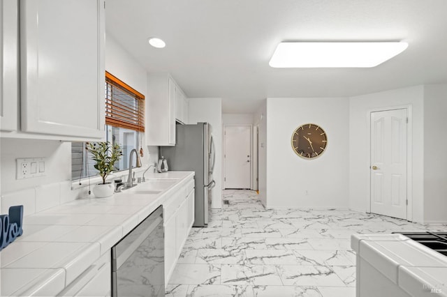 kitchen with white cabinetry, tile countertops, dishwasher, and sink