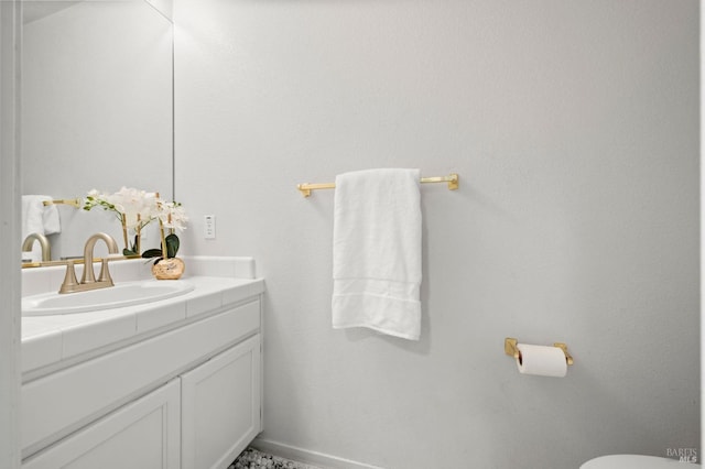 half bath featuring toilet, vanity, and baseboards