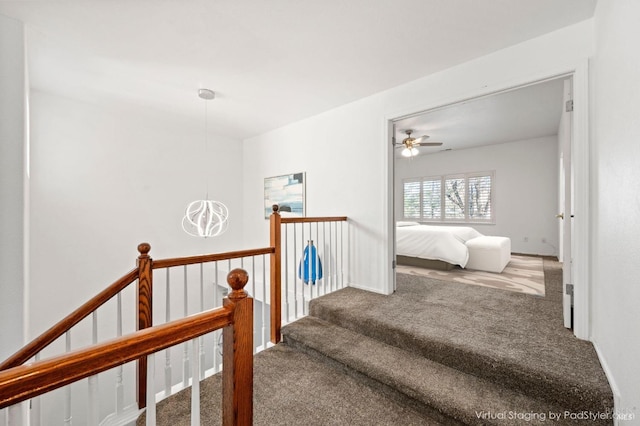 staircase with carpet flooring and a chandelier