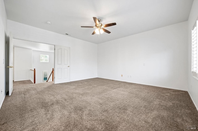 carpeted empty room with a ceiling fan