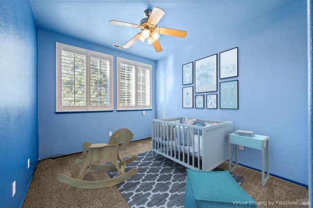 bedroom with a nursery area, visible vents, and ceiling fan