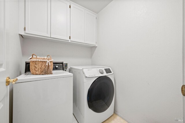 clothes washing area featuring cabinet space, baseboards, and independent washer and dryer