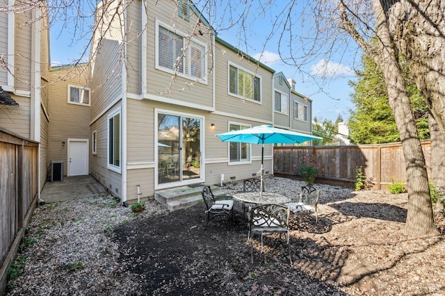 back of house with entry steps, a fenced backyard, a patio, and central AC unit