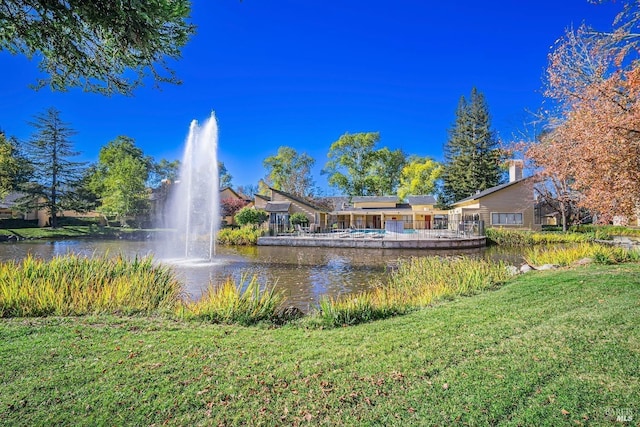 view of community with a yard and a water view