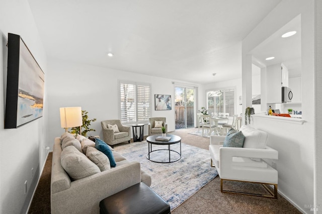 living area with baseboards, recessed lighting, and light colored carpet