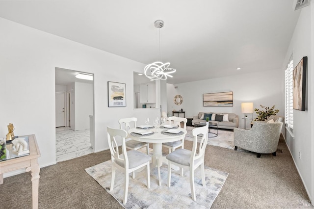 carpeted dining room with an inviting chandelier