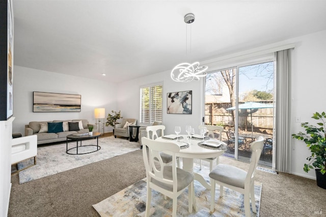 dining space with carpet flooring and a notable chandelier