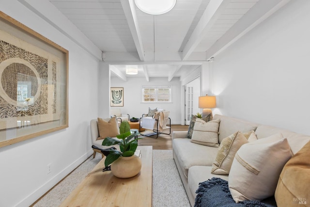 living room with baseboards, beam ceiling, and wood finished floors